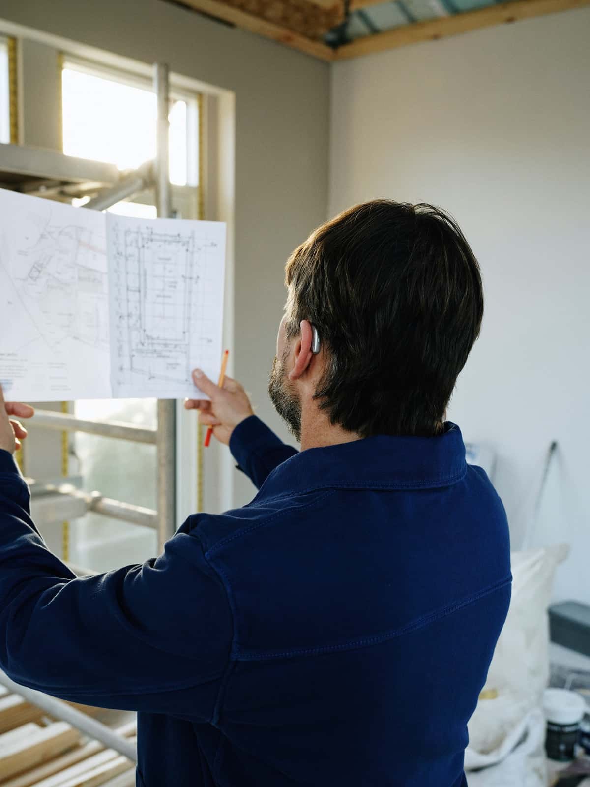 Contractor reviewing blueprints on an active construction project